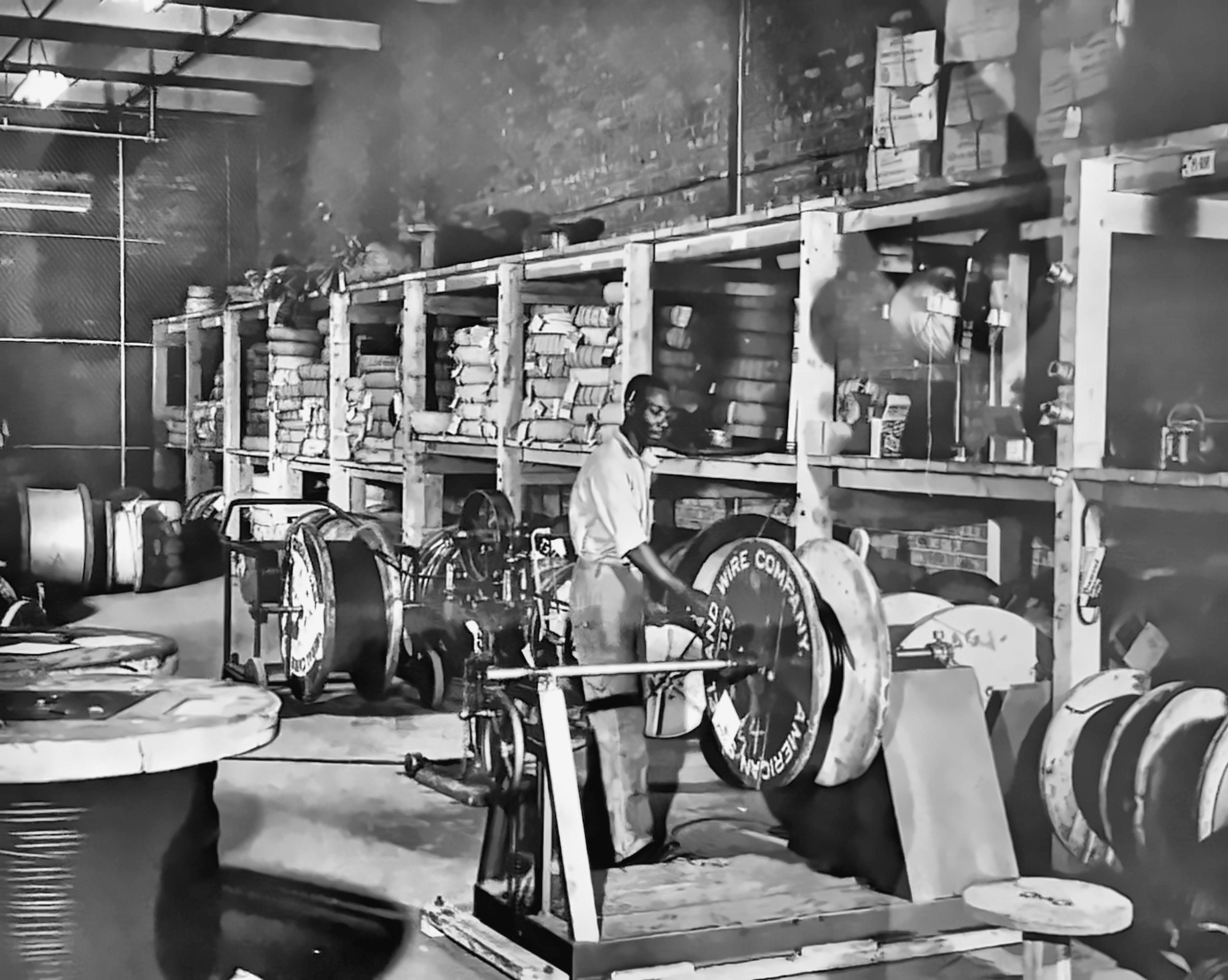 Historic photo of an Efengee employee measuring wire off a spool