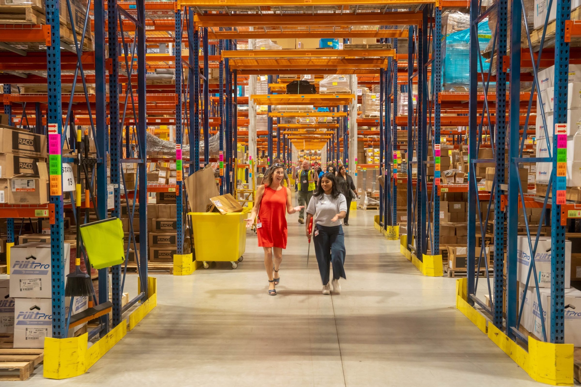 Team members walking through warehouse aisles